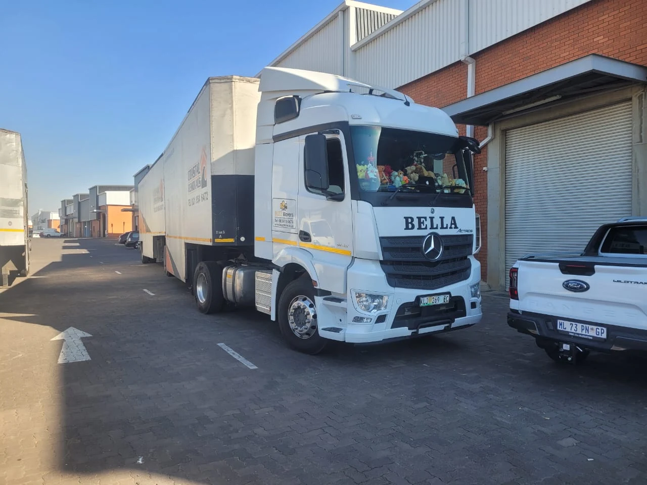 A Buzz Movers Mercedes truck with the company logo on the door