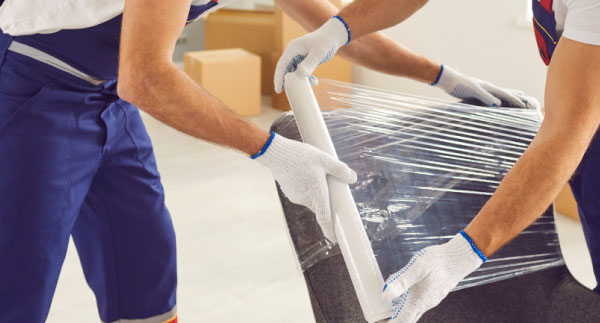 Buzz Movers packer wrapping and boxing household items before a long distance move